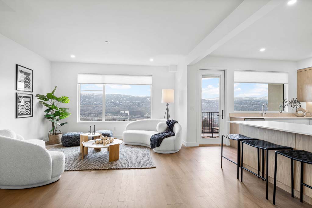 Primary bedroom with wood accent wall, large window, and neutral furnishings